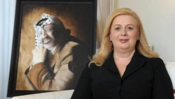 سهى ارملة الزعيم الفلسطيني الراحل ياسر عرفات تقف بجانب صورته