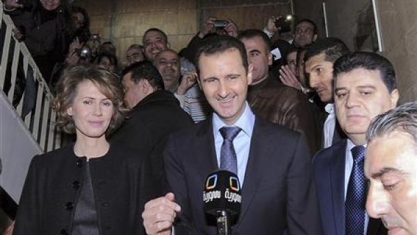 الرئيس السوري بشار الاسد وزوجته امام وسائل الاعلام بعد المشاركة في التصويت بمبنى تابع للتلفزيون السوري في دمشق يوم الاحد
