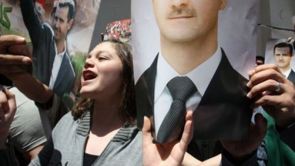 مؤيدون للاسد يرفعون صوره قبل الادلاء باصواتهم في دمشق
