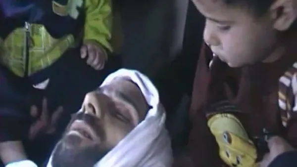 صورة من شريط على يوتيوب الجمعة 4 تشرين الثاني/نوفمبر يظهر طفلين جالسان قرب جثة قتيل ذكر ناشطون انه اسمه يحي الحمد من باب عمرو في حمص
