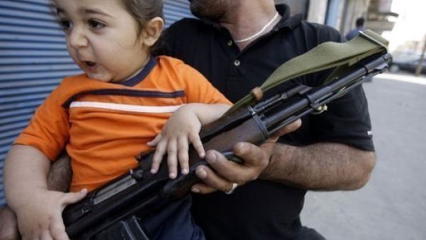 مسلح يحمل طفلا في طرابلس