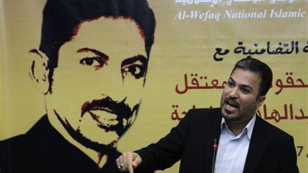 عضو بجمعية الوفاق يتحدث امام صورة للناشط عبدالهادي الخواجة
