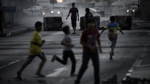 Bahraini boys run for cover during clashes following an anti-regime rally in support of political activists held in prison in the village of Jidhafs, west of Manama on Monday. (Photo:  AFP /MOHAMMED AL-SHAIKH) - Photo used for illustrative purposes - 