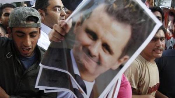 سوريون يعيشون في لبنان يحملون صور الرئيس بشار الاسد في مظاهرة مؤيدة لحكومته في بيروت
