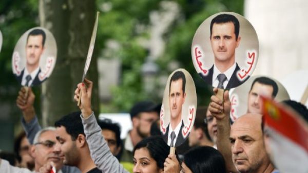Demonstrators raise portraits of Syrian President Bashar Assad on September 8, 2013 in Brussels to protest against a potential military strike against Syria. (AFP)
  Demonstrators raise portraits of Syrian President Bashar Assad on September 8, 2013 in Brussels to protest against a potential military strike against Syria. (AFP)