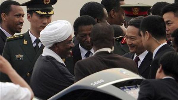 الرئيس السوداني عمر البشير (الثالث من جهة اليسار) يصافح المسؤولين الصينيين لدى وصوله مطار بكين الدولي يوم الثلاثاء.