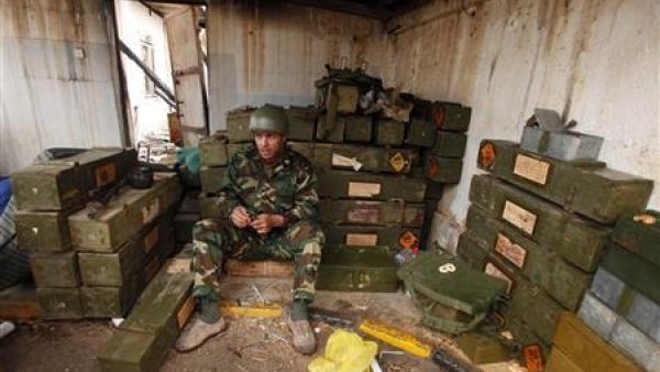 مدني انضم إلى افراد الجيش الذين انقلبوا ضد نظام القذافي داخل مستودع ذخيرة في بنغازي
