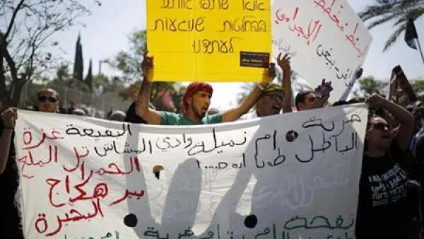 محتجون يرفعون لافتات أثناء مظاهرة في بئر السبع جنوب اسرائيل يوم الاثنين تضامنا مع بدو النقب الذين تريد الحكومة الاسرائيلية مصادرة أراضيهم
