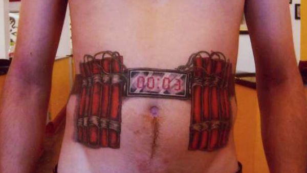 A man gets a tattoo of bombs strapped to his stomach. 