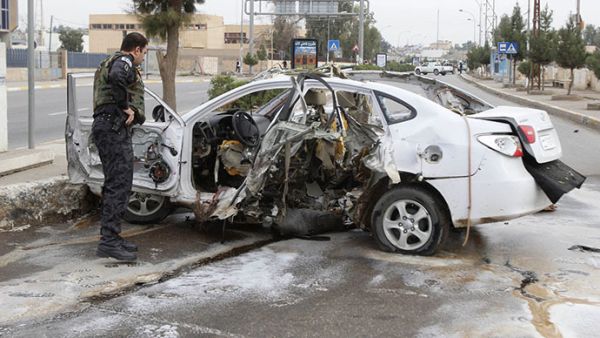 Security officials examine a car after a bomb in Kirkuk Wednesday (Reuters)