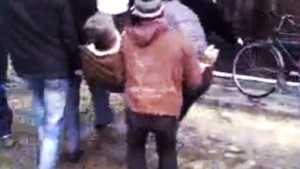 رجال يحملون جريحا في حمص
