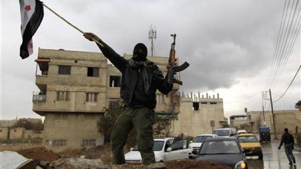 جندي سوري منشق يلوح بعلم المعارضة السورية في دمشق
