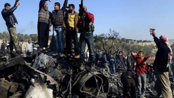 Syrian rebels celebrate the downed jet of Assad's forces.
