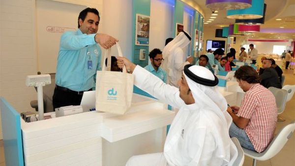 du employee handing a cotton bag to one of the customers as part of du World Environment Day initiative in aims to reduce the use of plastic bags du employee handing a cotton bag to one of the customers as part of du World Environment Day initiative in aims to reduce the use of plastic bags
