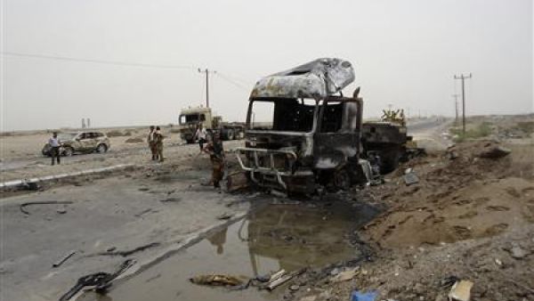 جنود يفحصون حطام السيارة الملغومة في موقع الهجوم 