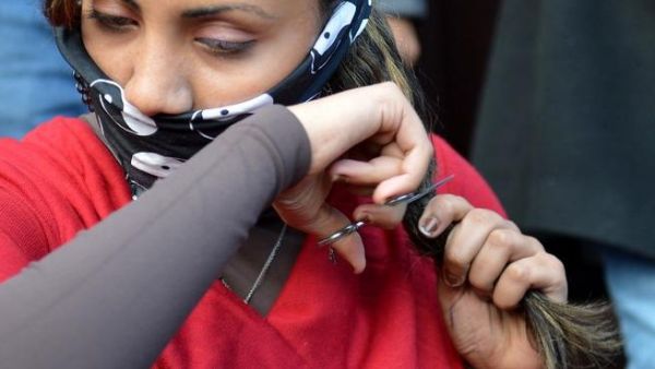 An Egyptian women cutting her hair in protest at the new constitution
