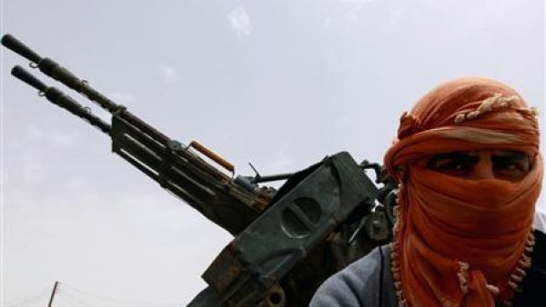 مقاتل من المعارضة الليبية يقف عند البوابة الغربية لمدينة اجدابيا