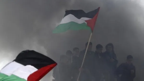 
فلسطينيون يرفعون اعلاما وطنية خلال تظاهرة في يوم الارض في بيت حانون