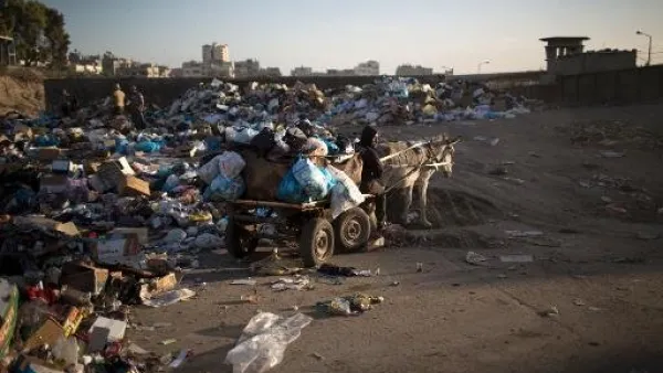 عمال بلدية غزة يستخدمون عربة يجرها حمار لجمع القمامة 
