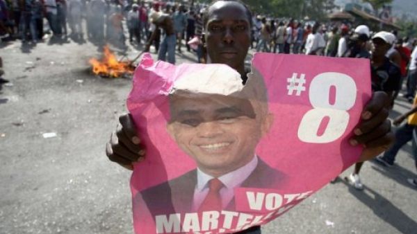 هايتي يحمل صورة المرشح الذي استبعد م الدورة الثانية للانتخابات الرئاسية ميشال مارتيلي في بيتيون فيل 