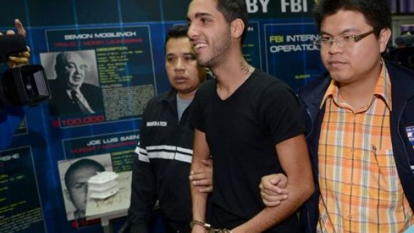 Algerian hacker Hamza Bendelladj is all smiles as he gets escorted towards a life behind bars. (photo courtesy of ArabCrunch )