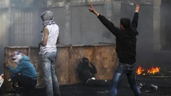  فلسطيني يلوح بعلامة النصر خلال اشتباكات مع جنود اسرائيليين في الخليل
