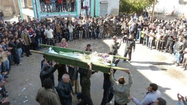 محتجون سوريون ينثرون الأرز فوق جثمان أحد ضحايا العنف في منطقة قرب حمص يوم السبت.