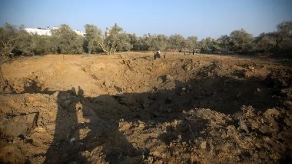 مدنيون فلسطينيون قرب حفرة تسببت بها غارة اسرائيلية في شمال قطاع غزة في 14 تشرين الثاني