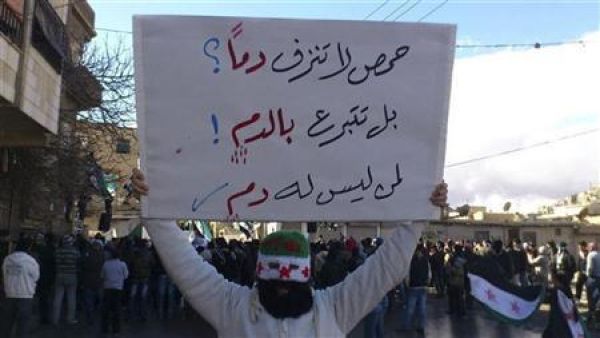 محتج يرفع لافتة خلال مظاهرة ضد الاسد قرب دمشق يوم الجمعة
