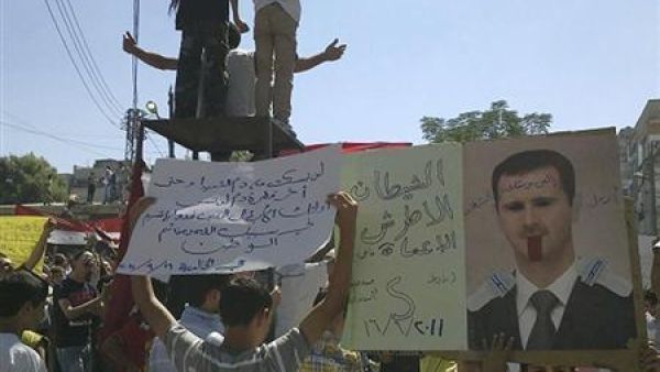اشخاص يحتجون ضد الرئيس السوري بشار الاسد في حمص 
