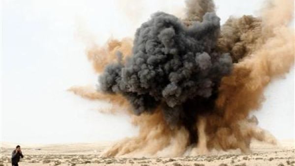 احد الثوار يسد اذنيه اثناء انفجار قنبلة القتها طائرة تابعة للقوات الجوية الليبية الموالية للزعيم معمر القذافي في الصحراء قرب البريقة