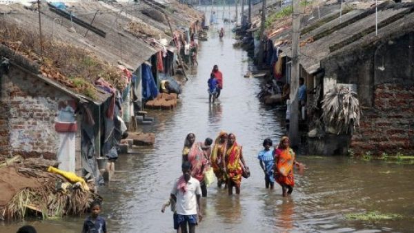 سكان قرية هندية يسيرون وسط شارع ملأته مياه الفيضانات 
