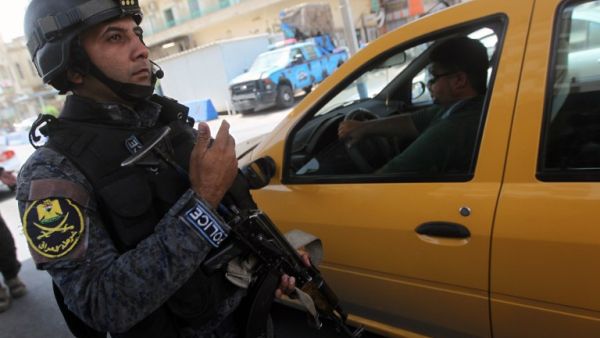 An Iraqi policeman checks vehicles on July 23 after security measurers were increased in Baghdad. (AFP / AHMAD AL-RUBAYE)