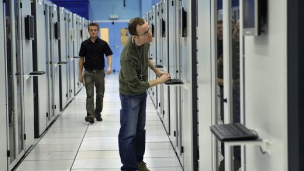 
عالمان يعملان على اجهزة كمبيوتر في المركز الاوروبي للابحاث النووية 