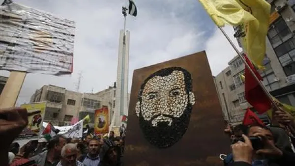فلسطينيون يرفعون صورة مرسومة بالخبز للسجين سامر العيساوي أثناء احتجاج في رام الله بالضفة الغربية