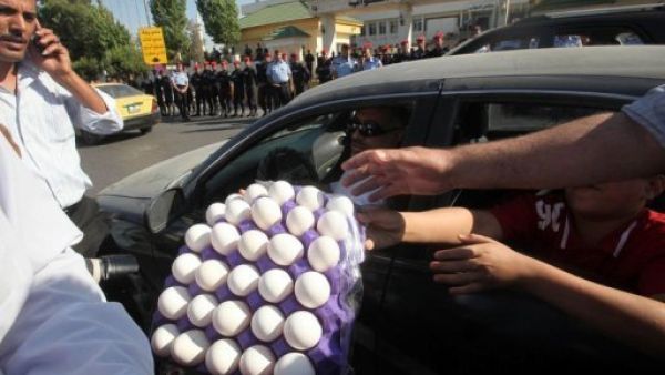 متظاهرون يوزعون البيض لرميه على مبنى البرلمان في عمان خلال التظاهرة الخميس
