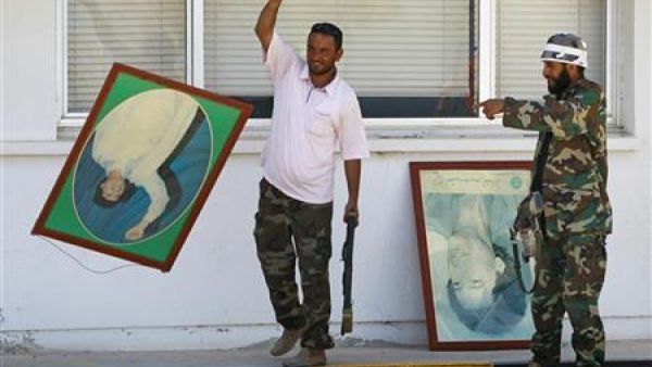 مقاتل من المعارضة يلقي صورة للقذافي على الارض عقب السيطرة على مصفاة نفط الزاوية غربي طرابلس
