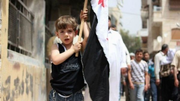 طفل يحمل علم الثورة السورية في كفرتخاريم خلال تظاهرة ضد النظام 
