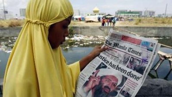 امراة مسلمة في العاصمة الفلبينية تقرا مقالا حول مقتل بن لادن