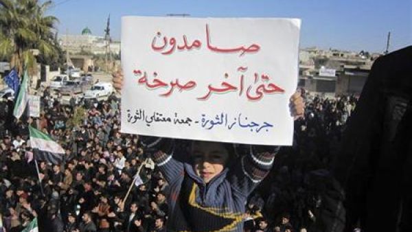 طفل يرفع لافتة ضد الرئيس السوري بشار الاسد بالقرب من ادلب