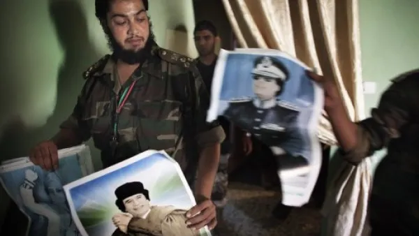 مقاتلون موالون للمجلس الانتقالي الليبي يفتشون احد المنازل في حي بو سليم في طرابلس

