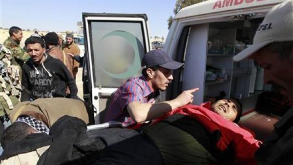 مقاتلون ينقلون زميلا لهم أصيب في اجدابيا يوم الأحد
