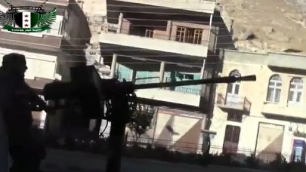  An image grab taken from a video uploaded on YouTube by Shaam News Network on September 4, 2013 allegedly shows a rebel fighter firing a heavy machine gun during a battle in Maaloula. (AFP)