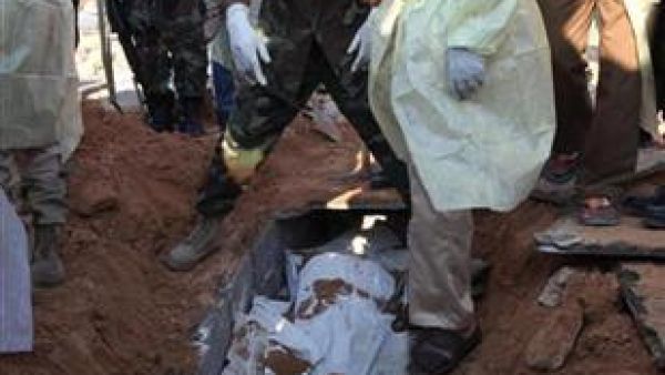 ثوار ومسؤولون صحيون ينتشلون جثثا من قبر جماعي في طرابلس ي