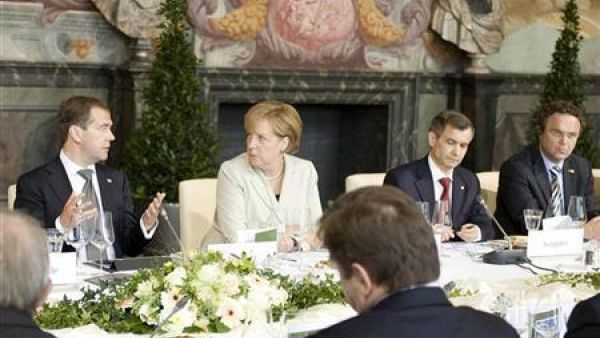 الرئيس الروسي (إلى اليسار) يتحدث الى المستشارة الالمانية خلال مأدبة غداء في هانوفر 
