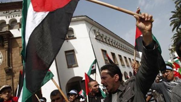 متظاهرون يرفعون علم فلسطين في مسيرة أمام البرلمان المغربي بالرباط 
