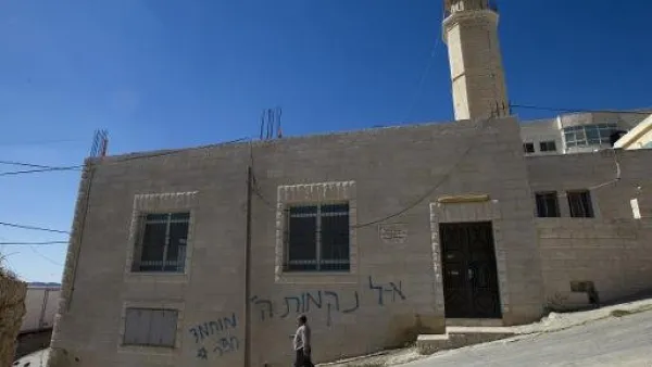 فلسطيني يمر امام مسجد كتبت عليه باليهودية عبارات مسيئة للنبي في بيت اكسا بالضفة الغربية
