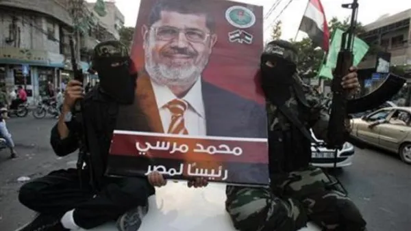 مسلحون من حماس يرفعون صورة للرئيس المصري المنتخب محمد مرسي 
