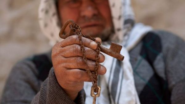 An old Palestinian man still holds the key to his old house taken from him in 1948.