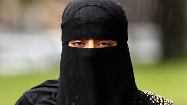 A woman wears a full face Niqab.